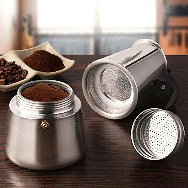 Cafeteira Inox Magnífica Casavelle aberta sobre bancada, exibindo filtro e pó de café, destacando design premium e praticidade.
