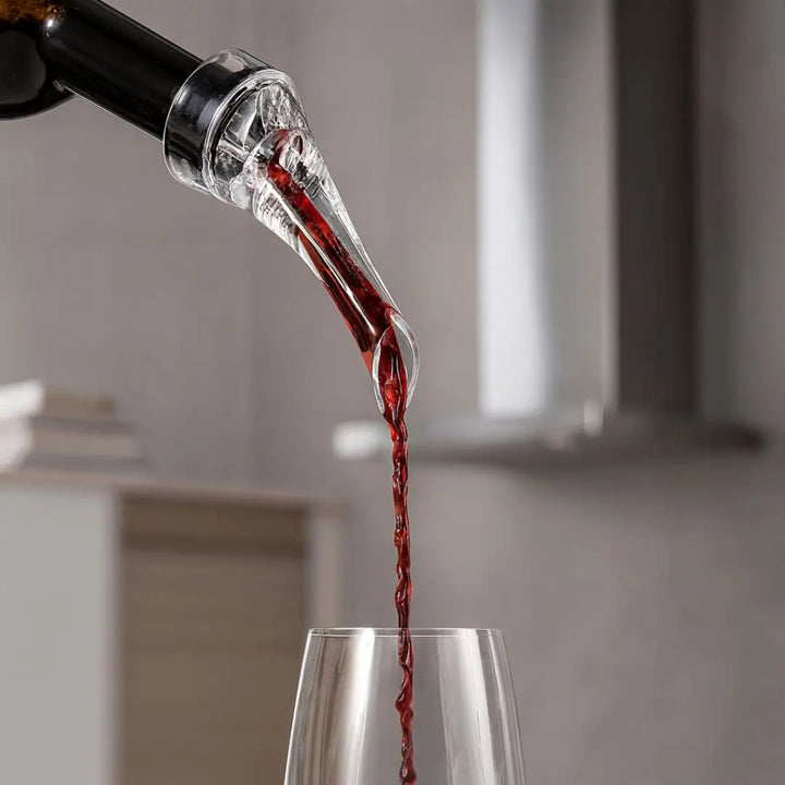 Aerador de Vinho Essence Casavelle servindo vinho tinto com fluxo suave diretamente na taça, destacando oxigenação instantânea em ambiente sofisticado.