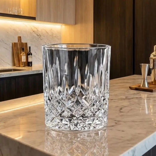 Copo de cristal lapidado Casavelle sobre bancada de mármore em cozinha moderna e sofisticada, com iluminação quente ao fundo.