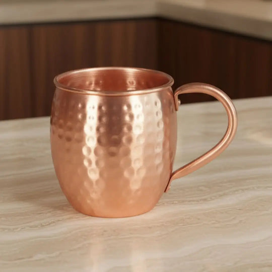 Copo para Drink Grand Mule Casavelle em aço inoxidável com acabamento martelado sobre bancada sofisticada