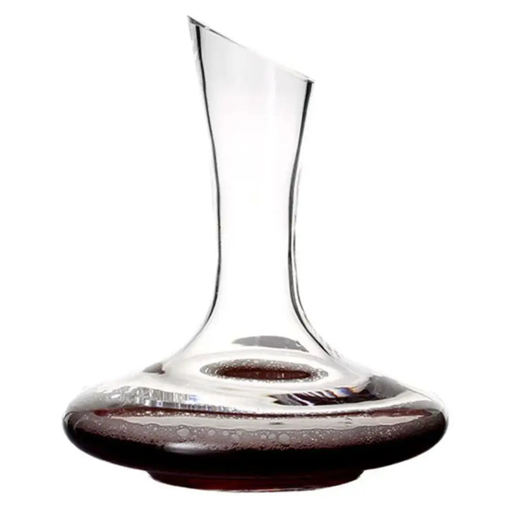 decanter de vinho em cristal transparente com vinho tinto na base sobre fundo branco.