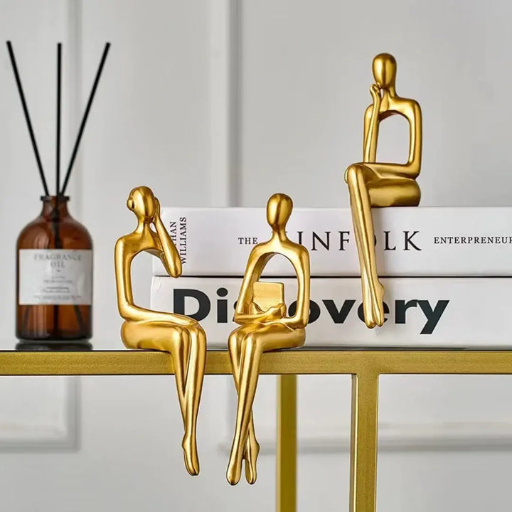 Estatuetas Leitor Sentado Casavelle decorando sala de estar, representando liderança, conhecimento e prestígio.