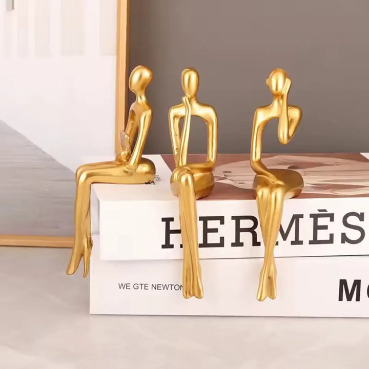 Coleção Leitor Sentado Casavelle com três estatuetas em resina de alto padrão para decoração sofisticada.