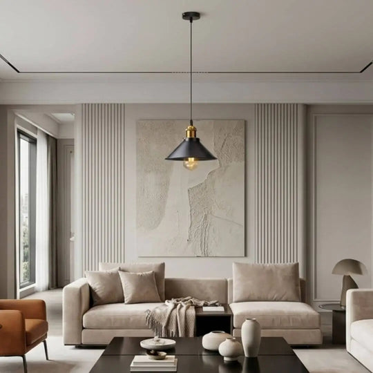 Luminária de teto estilo vintage preta com detalhes dourados iluminando sala de estar sofisticada com sofá bege, mesa de centro preta e decoração minimalista.