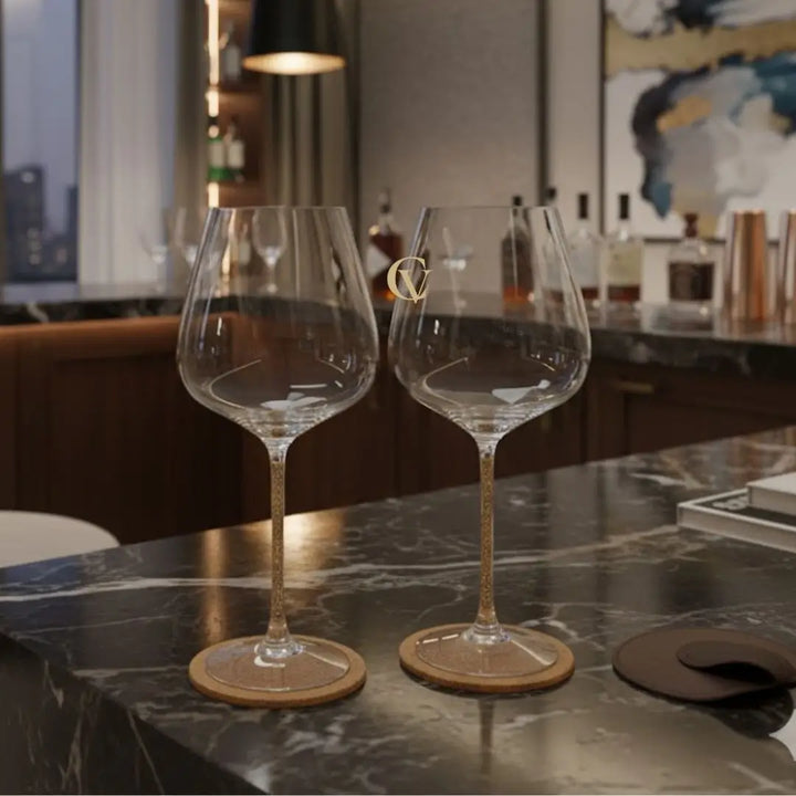 conjunto de taças de vinho prime casavelle com haste dourada sobre bancada de mármore.