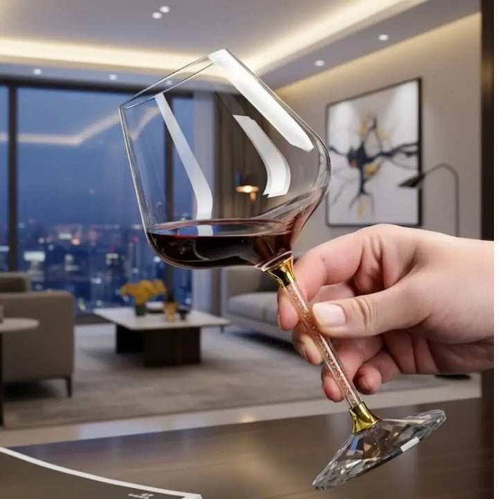 taça de vinho prime casavelle com haste dourada sendo segurada em ambiente sofisticado.